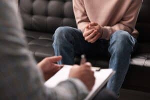Psychiatrist writes down diagnosis while talking to patient